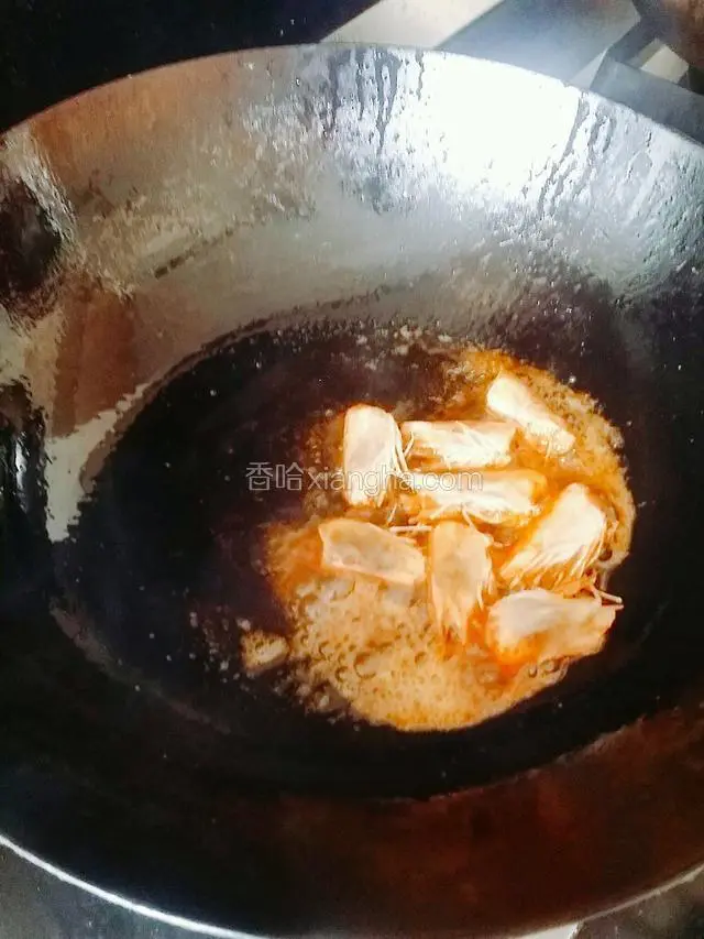 放入虾头，小火煸炒