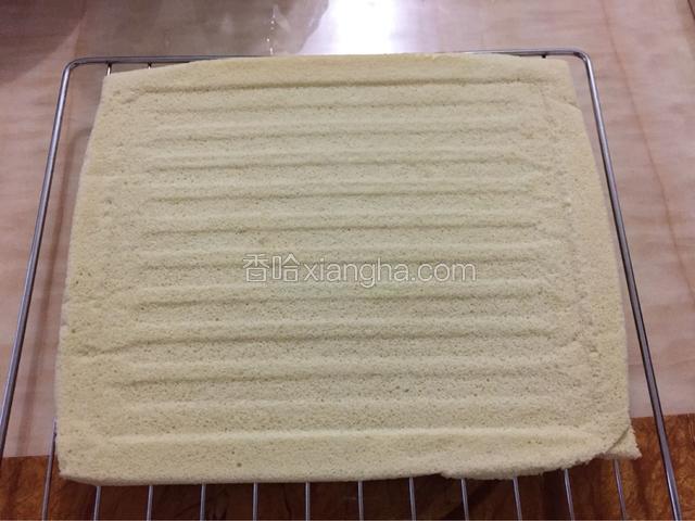 取出蛋糕，反扣在烤架上，趁热撕开油纸，等待放凉。