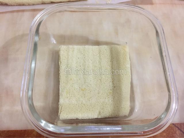 切一片与盒子底部一样大的蛋糕，铺好。