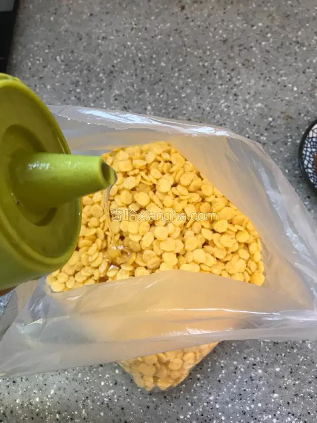 把玉米片放入保鲜袋，倒入适量食用油