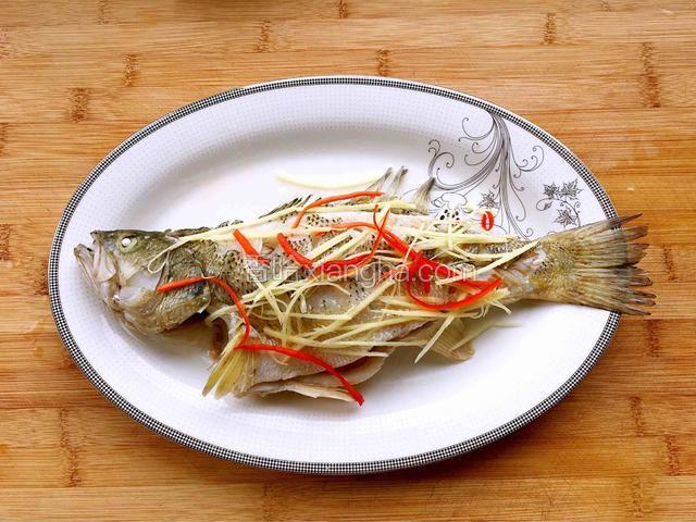 把姜丝和红椒丝铺在鱼身上