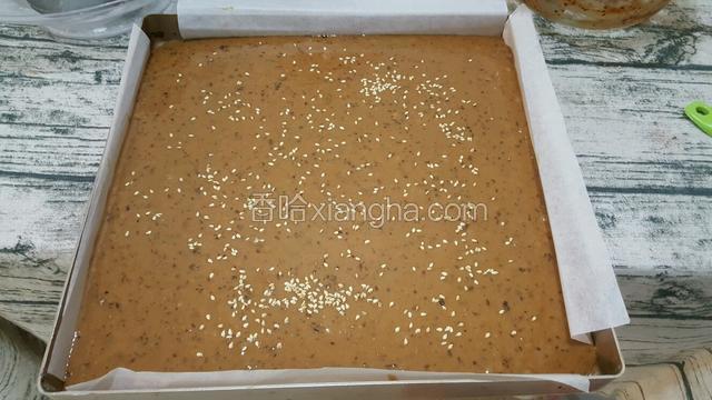 烤箱160度预热，烤盘盖上一层油纸，倒入枣糕糊，表面撒上熟芝麻点缀。