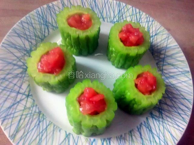 西红柿拌匀，用小勺加入苦瓜盅里。