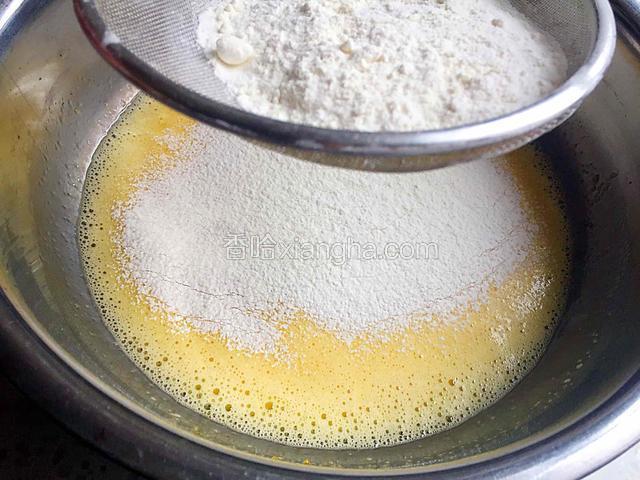 低粉筛入蛋黄液中用打蛋器划一字式或用硅胶刮刀用翻拌的手法轻轻从底部往上翻拌至无干面粉和面疙瘩。（不可划圈搅拌）