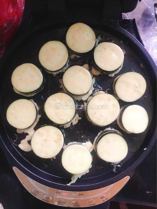 将裹好面糊的茄夹依次放入电饼档中煎制。（如果是油锅炸，也是依次放入炸，中小火炸制）