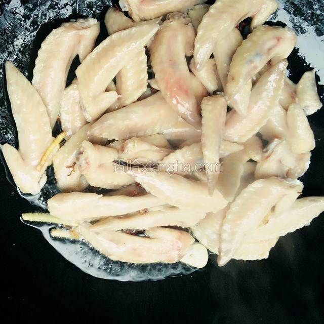 接着下入鸡翅尖翻炒到金黄色