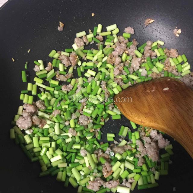倒入蒜薹开中小火继续翻炒，炒的过程分次加入清水，至蒜薹断生