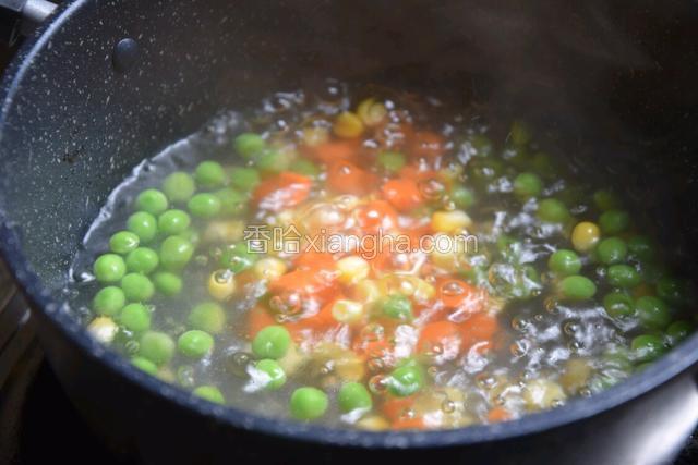 将玉米粒、胡萝卜跟豌豆放锅里煮熟捞出