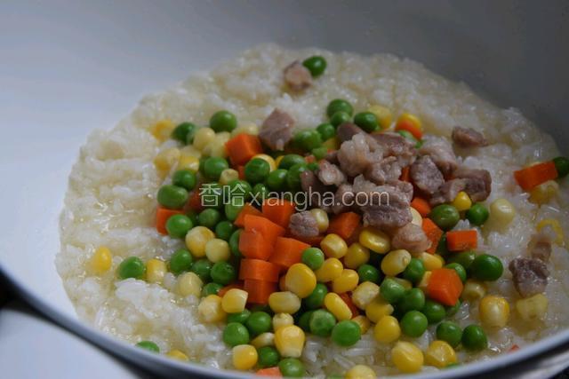 倒入玉米粒、胡萝卜、豌豆跟肉丁，翻炒几分钟