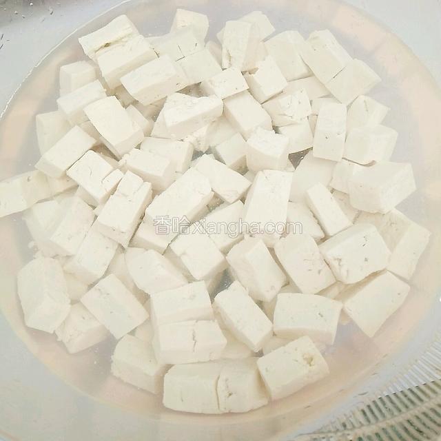将煮好的豆腐丁放入凉水中浸泡一会，除去豆腐中的热气。