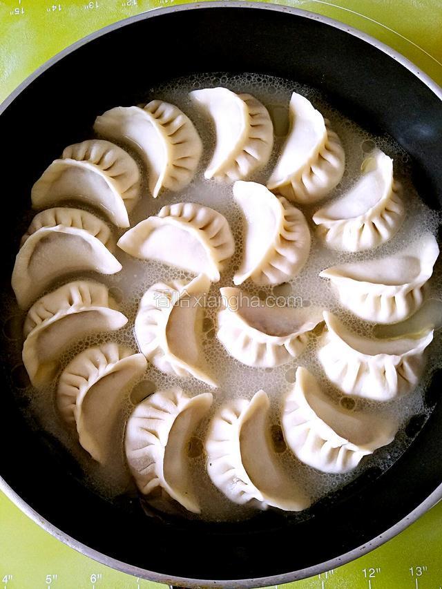 倒入调好的面粉水，水到饺子的三分之二处盖好盖。点火，先大火烧开后转中火煎。8——10分钟听见滋啦滋啦的声音，锅烙就好了。