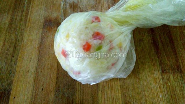把炒好的饭放入朔料带里，揉成饭团，放上