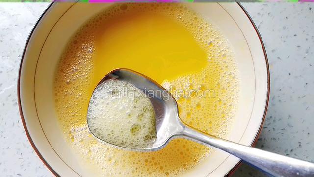 用勺子撇去蛋液表面的浮沫。