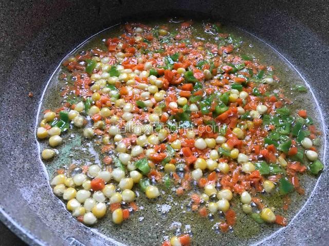 先将玉米、胡萝卜跟青椒倒入锅中翻炒熟