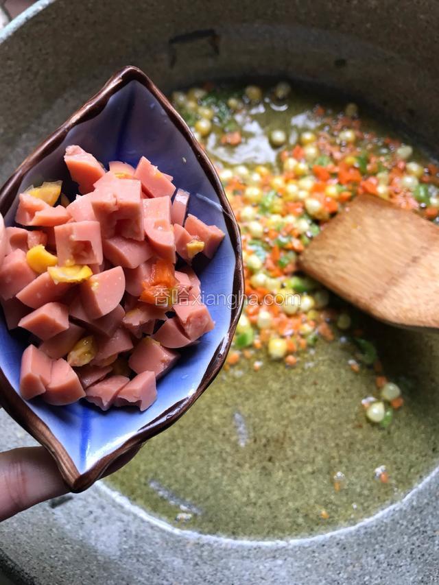 然后再将火腿肠倒入锅里，翻炒几下
