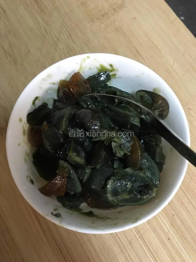 皮蛋用汤匙切成碎片。