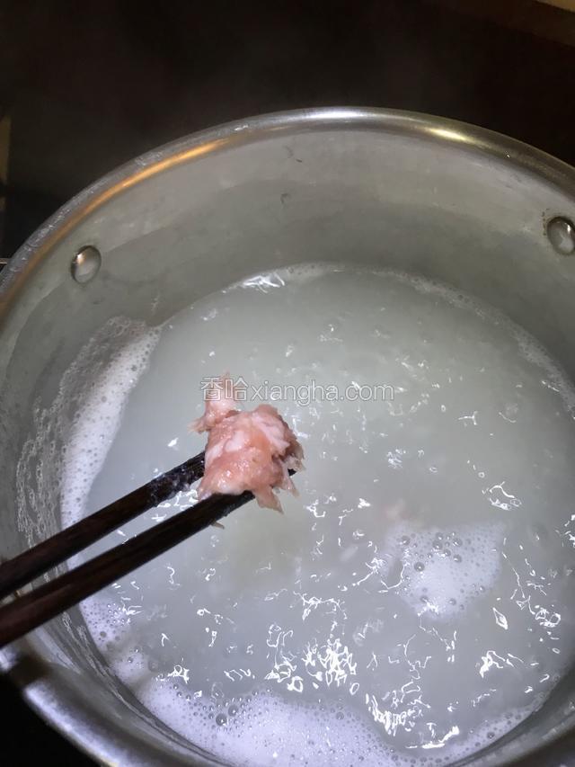 肉末用筷子夹成一小块一小块的放入沸腾的粥中。