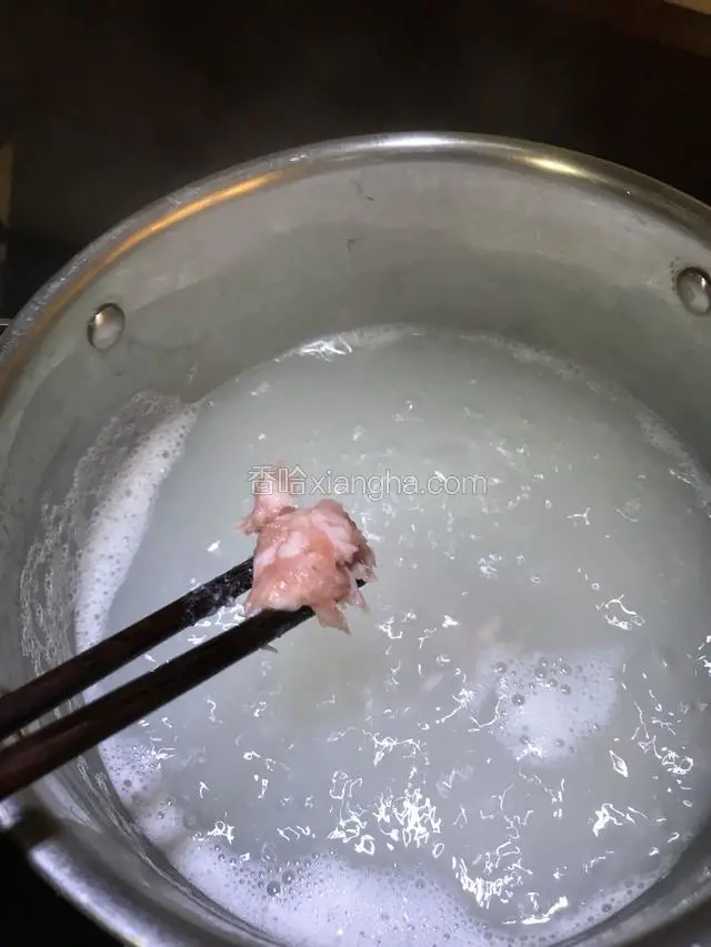 肉末用筷子夹成一小块一小块的放入沸腾的粥中。