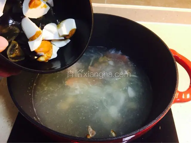 煎好的蒜放入汤锅，同时倒入皮蛋和咸蛋丁转大火煮约10分钟