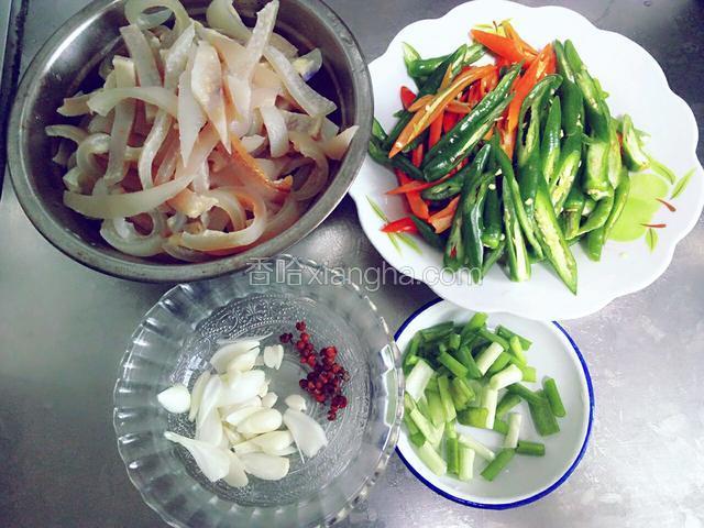 准备食材:肉皮提前洗净煮熟切条，青红椒切斜丝，蒜切片，葱切小段