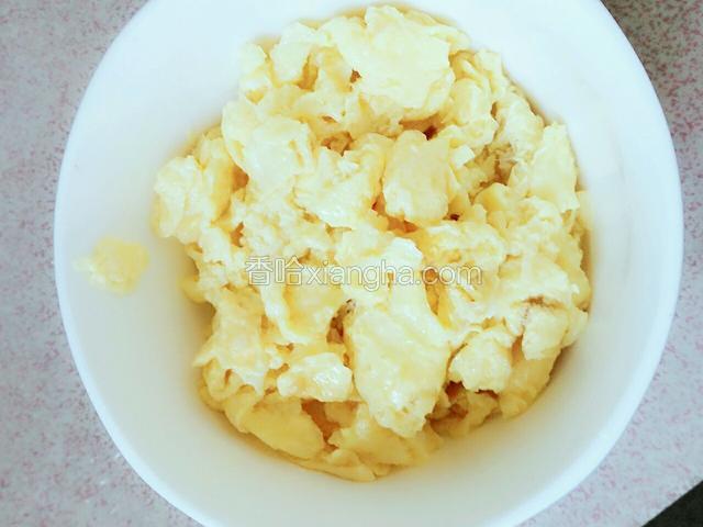 用锅铲捣碎炒好的鸡蛋，盛起来。