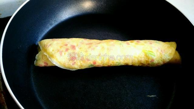 待鸡蛋液将要凝固时卷起。