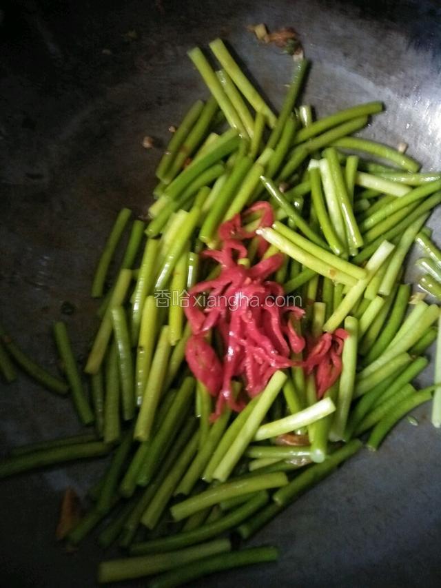 留底油倒入蒜薹和红辣椒翻炒