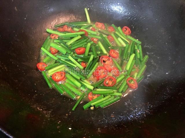 锅中留底油，倒入韭花、红尖椒，加适量盐翻炒均匀