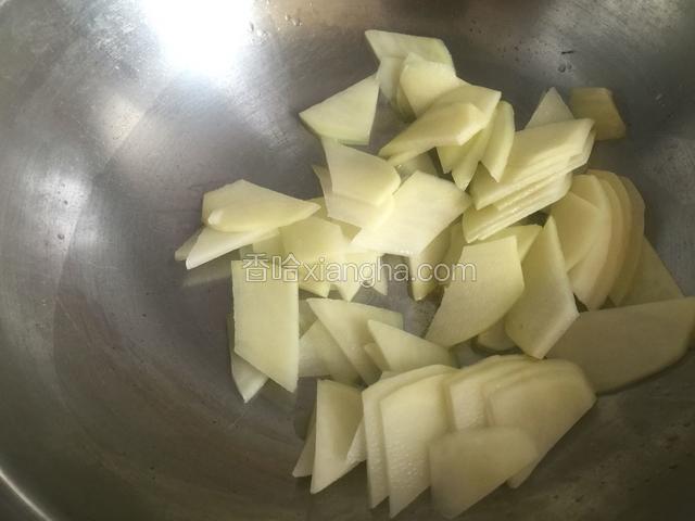 锅内放油烧热，放入土豆片翻炒片刻。