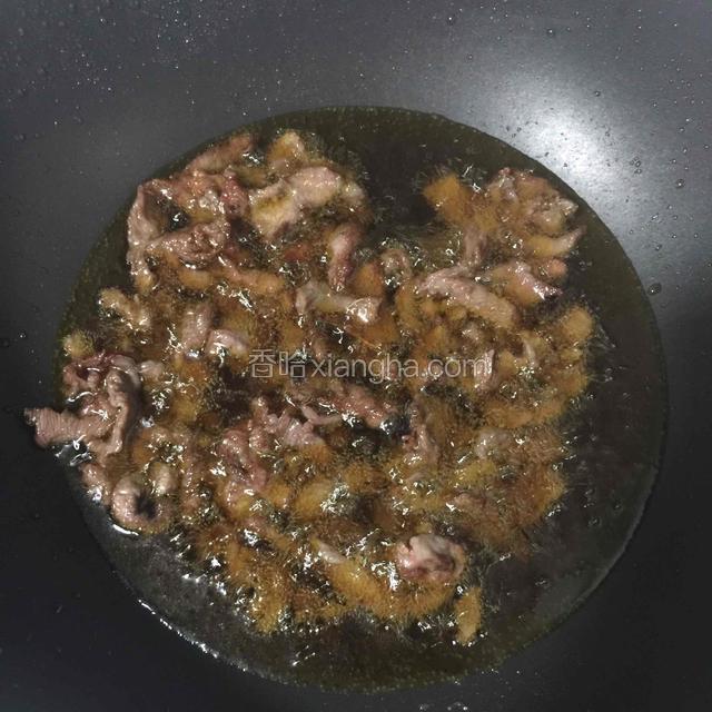 待油烧至六成热后放入牛肉，小火炸至变色