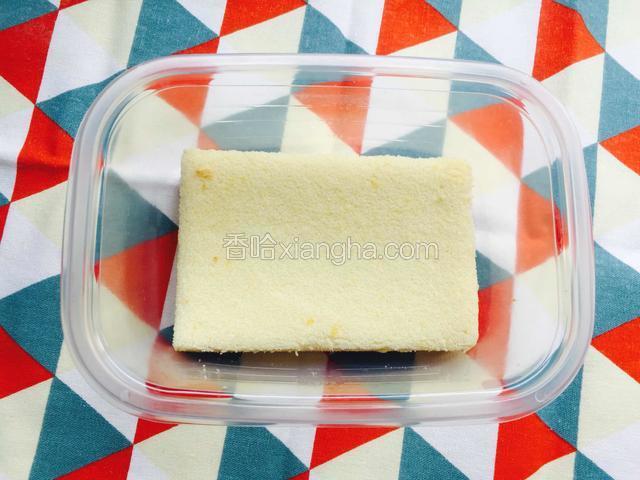 取一个蛋糕片放入盒子底部。