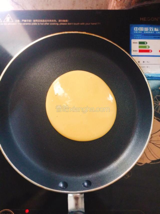平底锅用小火烧热，舀一勺面糊垂直倒入锅中，面糊会直接摊开成圆形状。