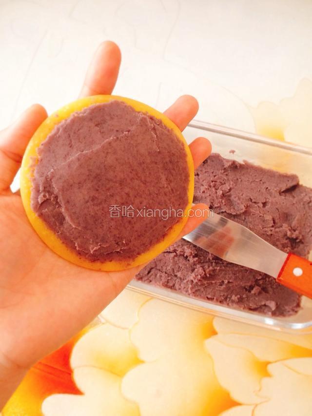 取一个饼皮，在不光滑的那面抹上适量的红豆沙。
