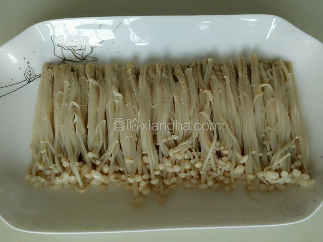 锅里坐水，水沸后放入金针菇煮3分钟捞出过凉水，控水后撒入少量盐拌匀摆于盘中
