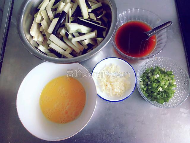 准备食材:茄子切成条,蒜和小葱切末,鸡蛋划散,调好料汁