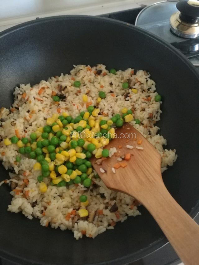 把焯好水的甜玉米粒，豌豆倒入锅里翻炒。
