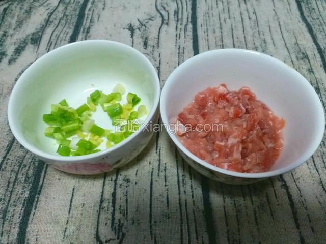 把猪瘦肉切成碎丁，放入适量水淀粉，拌匀，把葱切葱花、姜切碎末。