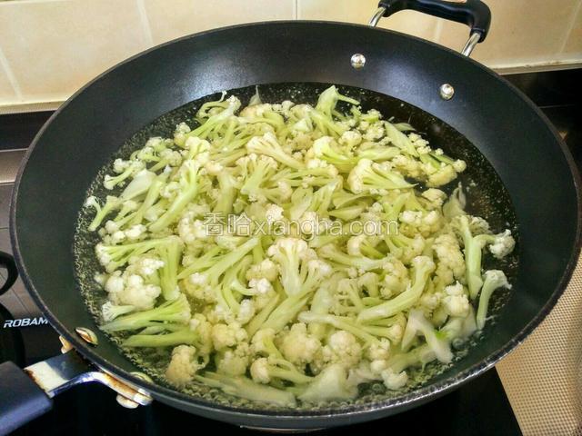 将菜花撕成小朵，入开水锅中焯熟。