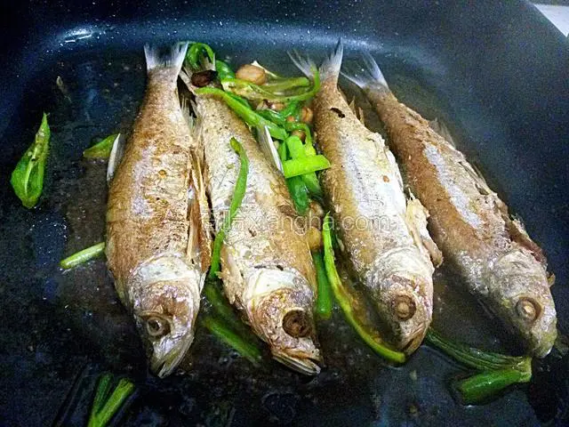 煎鱼。油烧开将鱼放入，小火，慢煎。用平底锅更好。一面煎好再煎另一面，直至两面鱼皮呈淡金色