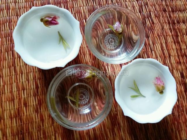 将溶解后的液体放入模具（我没有正规的冰激凌类的模具，就用品茗杯代替了），然后放入泡软的茶叶和玫瑰花，放置冷却即成冰粉；