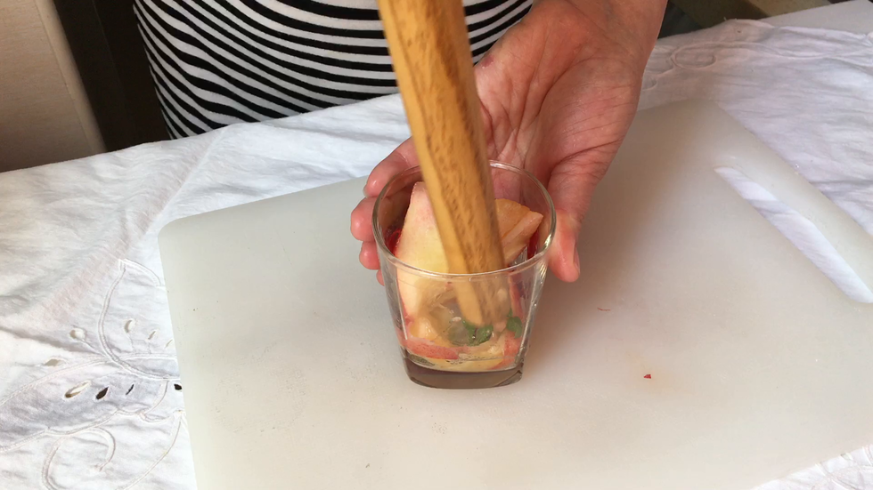 将桃片与薄荷叶放进杯子里捣碎