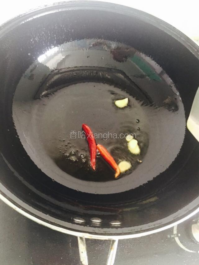 在刚才的油里炒蒜片红干椒，十秒即可。取出装盘放在一边备用。