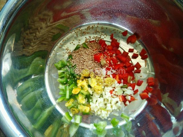将青红椒丁蒜末和白芝麻放入耐热的料理盆中，我临时又加了两根野山椒。