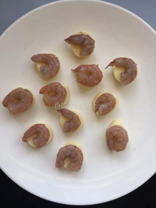 豆腐摆在盘子里，每个豆腐上放一只虾仁