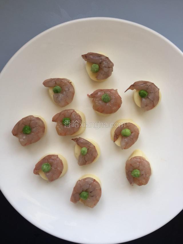 每个虾仁中间摆一颗豌豆，颜色搭配起来好看，上锅蒸5分钟