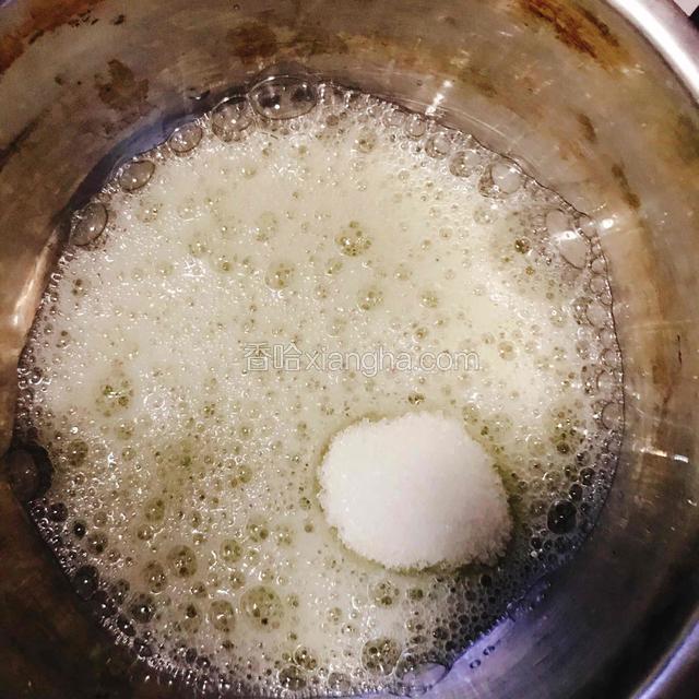 用电动打蛋器将蛋清打至出现泡泡，第一次加入糖。