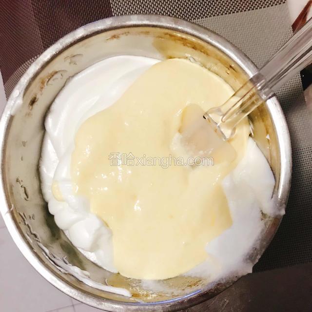 然后将混合好的蛋黄糊全部倒入打发的蛋白中。