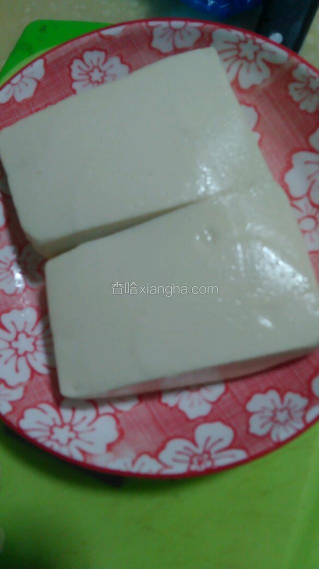 购买嫩豆腐一块从中间切开一分为二。用温盐水浸泡十五分钟。然后倒去水用一小瓢盐抹均豆腐。