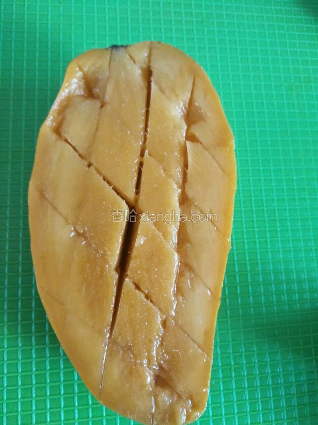 横几刀竖几刀划开，不要划破皮，两只手拿住芒果两头向上翻开