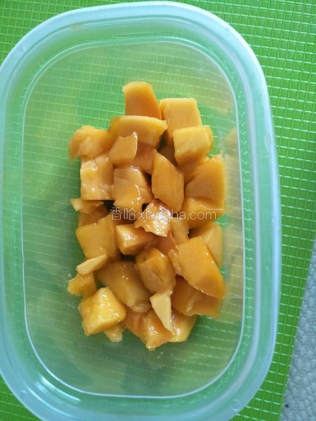 把芒果肉铺一层在盒子底部